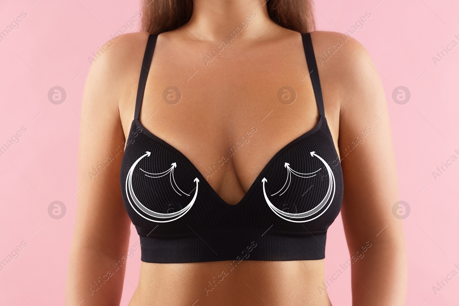 Image of Breast surgery. Woman with markings on bra against pink background, closeup