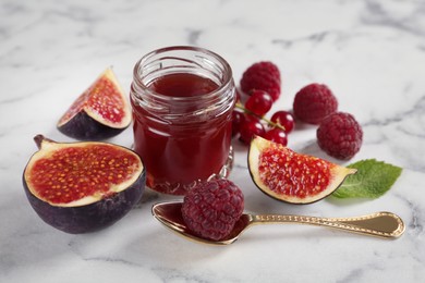 Photo of Jar of sweet jam and ingredients on white marble table