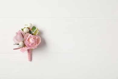 Photo of Beautiful boutonniere on white background, top view. Space for text