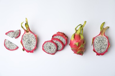 Delicious cut and whole dragon fruits (pitahaya) on white background, top view