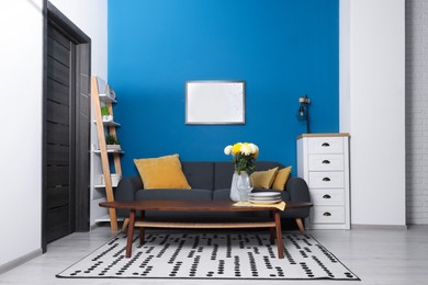 Photo of Stylish living room interior with comfortable grey sofa and coffee table