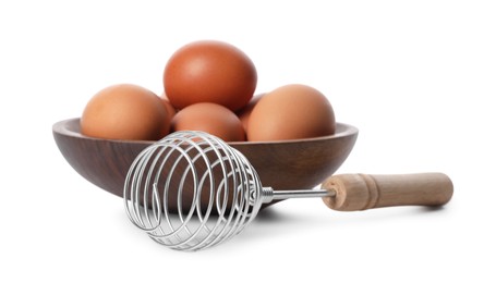 Photo of Whisk and bowl with raw eggs isolated on white