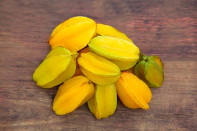 Delicious ripe carambolas on wooden table, flat lay