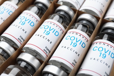 Photo of Glass vials with COVID-19 vaccine in package, closeup