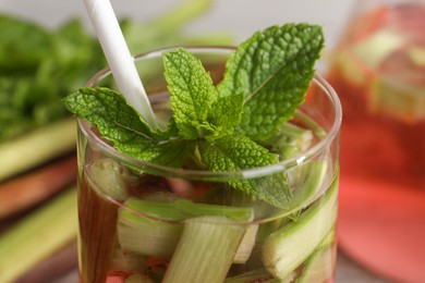 Glass of tasty rhubarb cocktail on blurred background, closeup