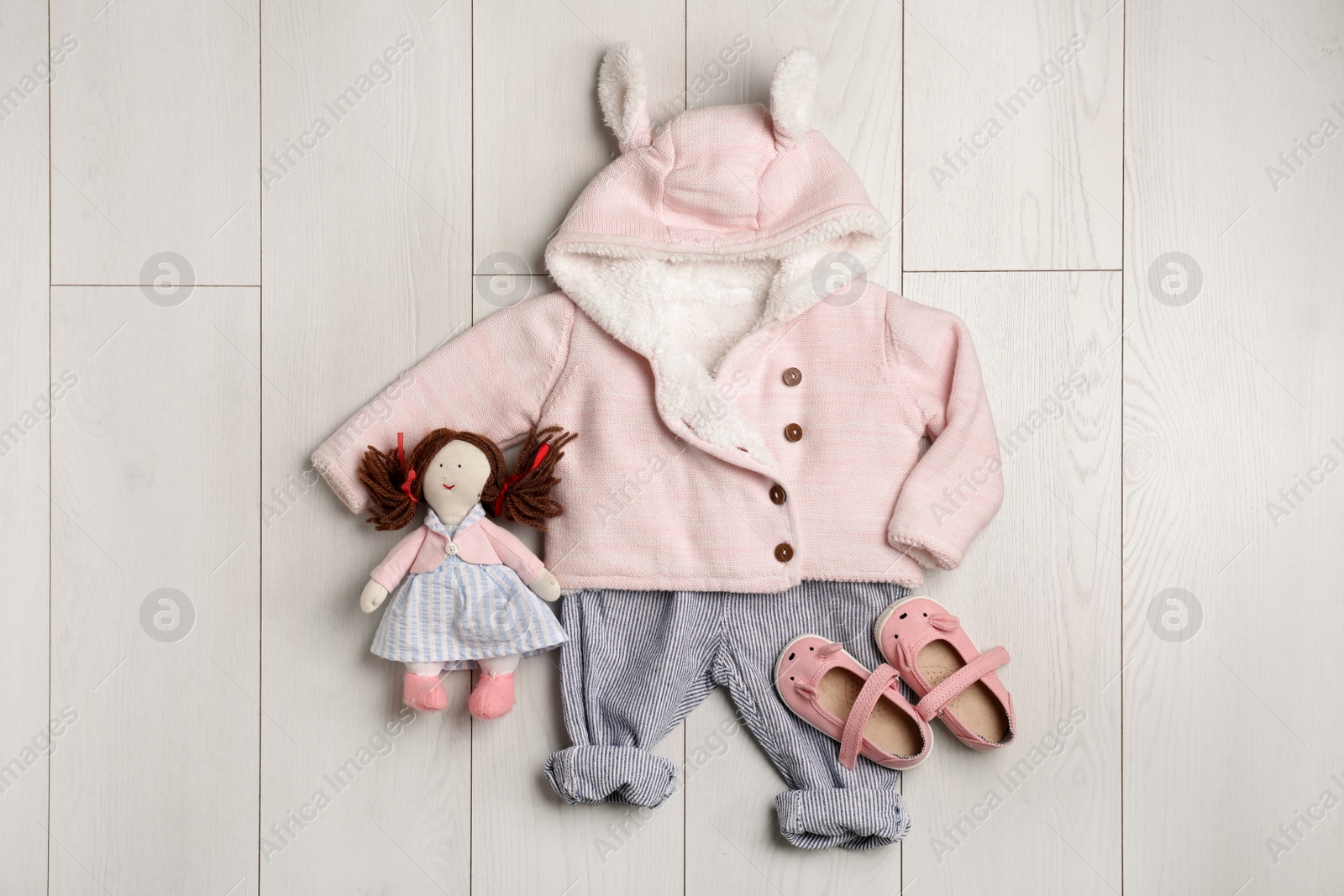 Photo of Flat lay composition with cute clothes on wooden background. Baby accessories