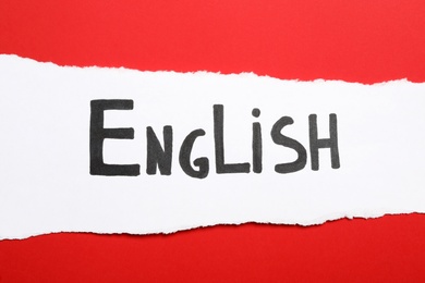 Paper with word English on red background, top view
