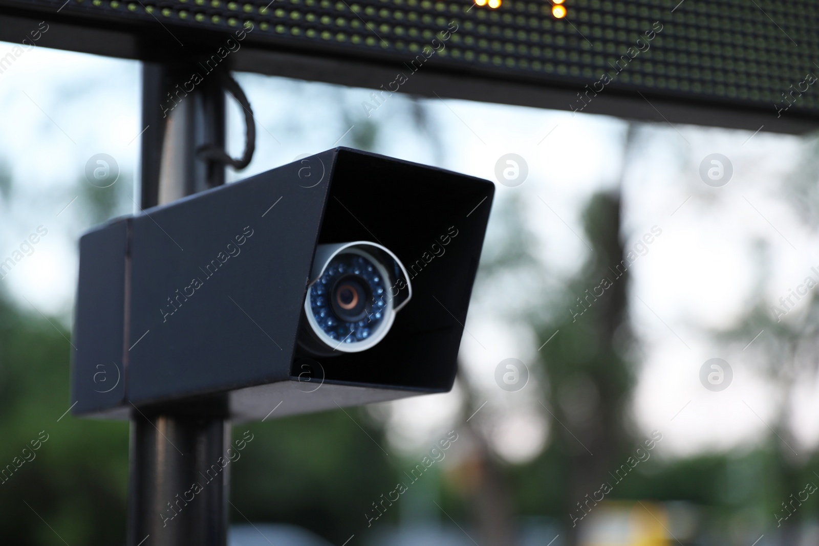 Photo of Modern CCTV security camera on street, closeup. Space for text