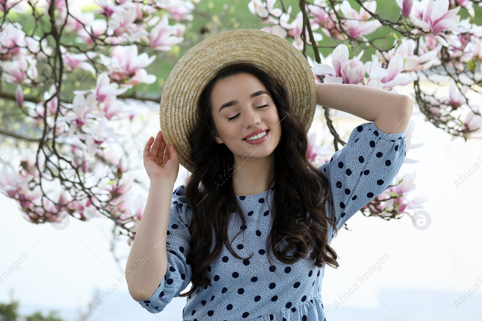 Photo of Beautiful woman near blossoming magnolia tree on spring day