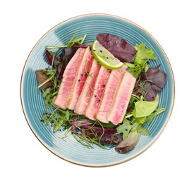Photo of Pieces of delicious tuna steak with salad isolated on white, top view