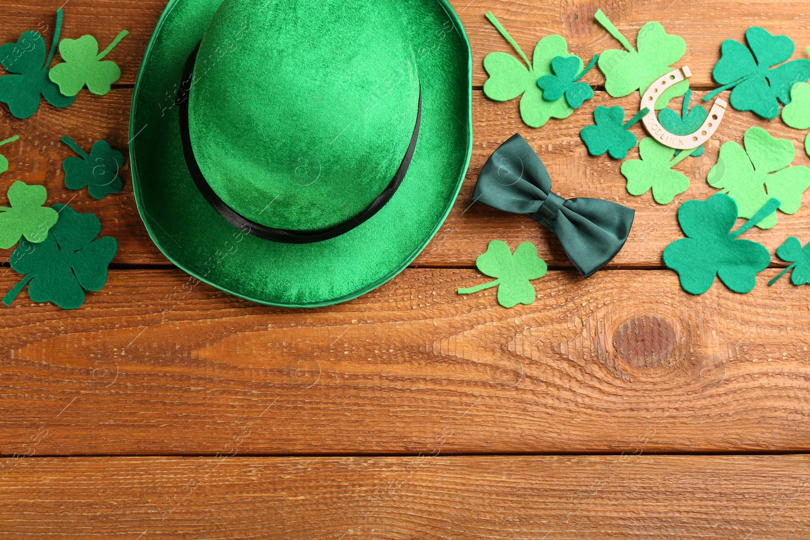 Photo of Leprechaun's hat and St. Patrick's day decor on wooden background, flat lay. Space for text