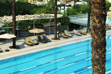 Empty sunbeds near outdoor swimming pool at resort