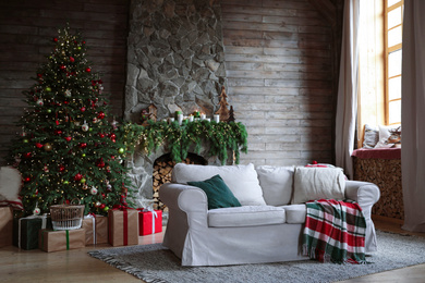 Photo of Festive interior with comfortable sofa and decorated Christmas tree