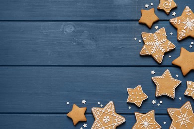 Photo of Tasty Christmas cookies on blue wooden table, flat lay. Space for text