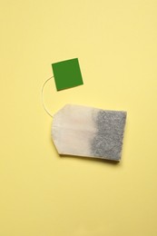 Photo of New tea bag with tab on beige background, top view