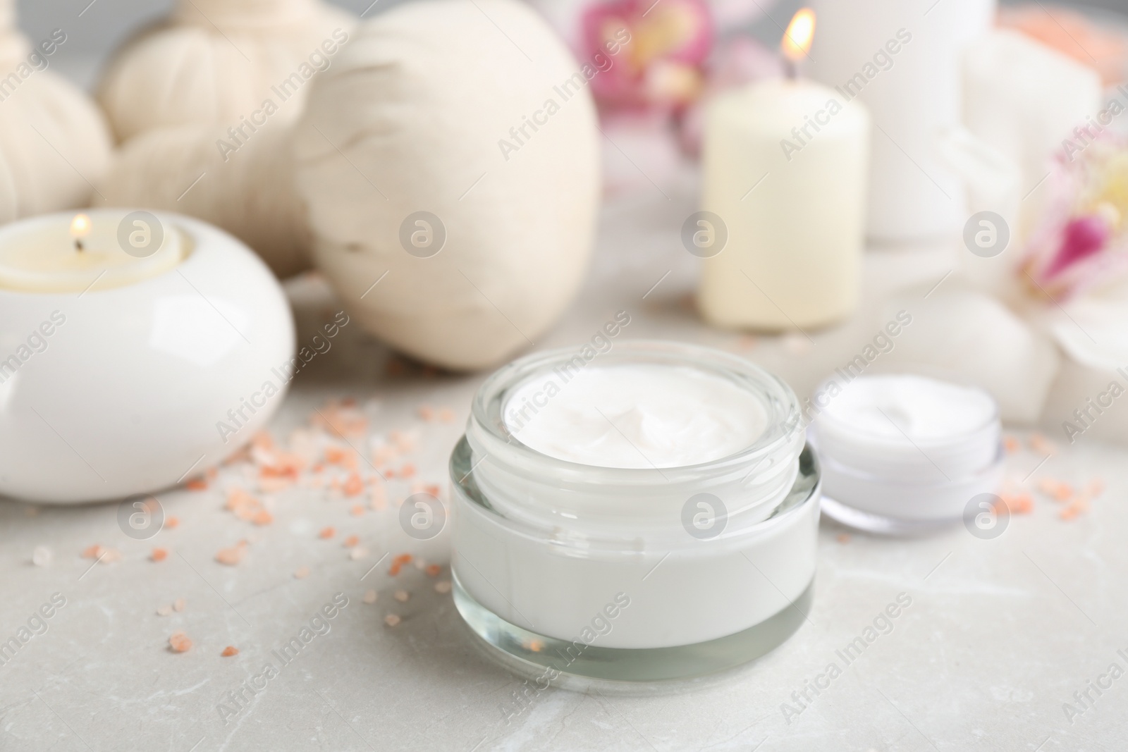 Photo of Beautiful spa composition with skin care products and candles on marble table, closeup