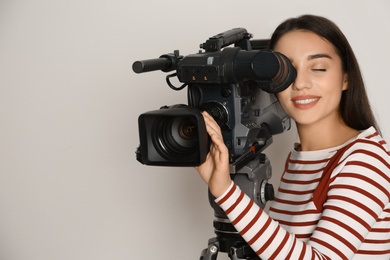 Operator with professional video camera on white background