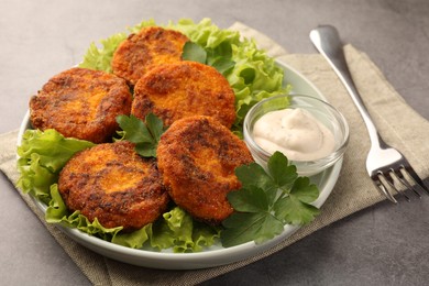 Photo of Tasty vegan cutlets served with sauce on light grey table, closeup
