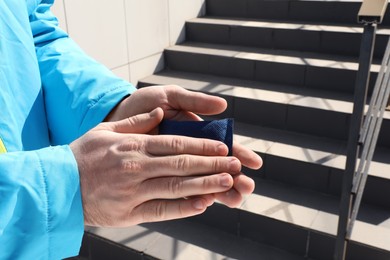 Man holding hand warmer outdoors, closeup. Space for text