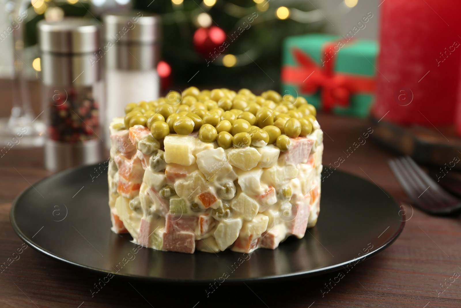 Photo of Traditional russian salad Olivier served on wooden table