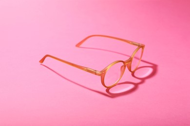 Photo of Glasses with corrective lenses on bright pink background