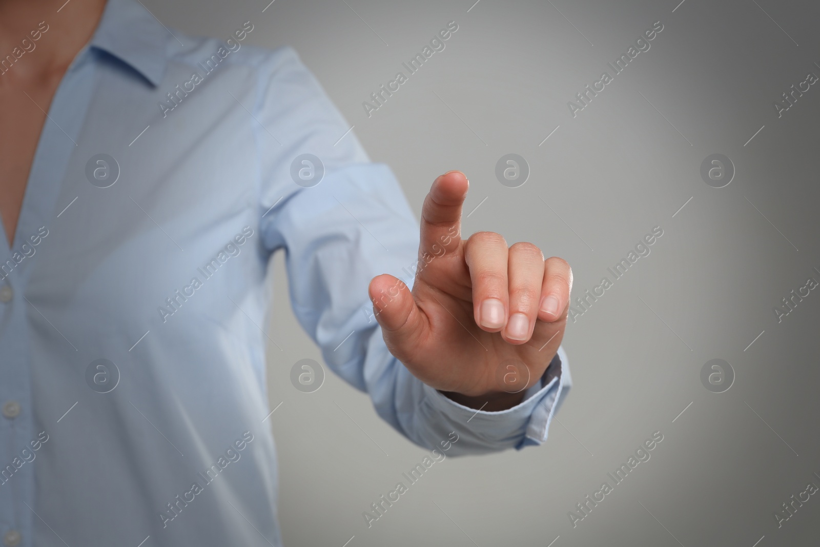 Photo of Woman touching something against grey background, focus on hand