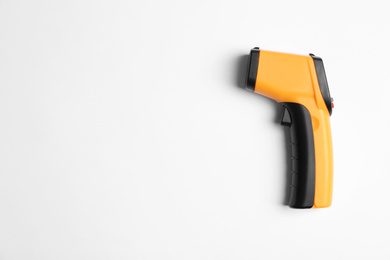 Photo of Modern non-contact infrared thermometer on white background, top view. Space for text