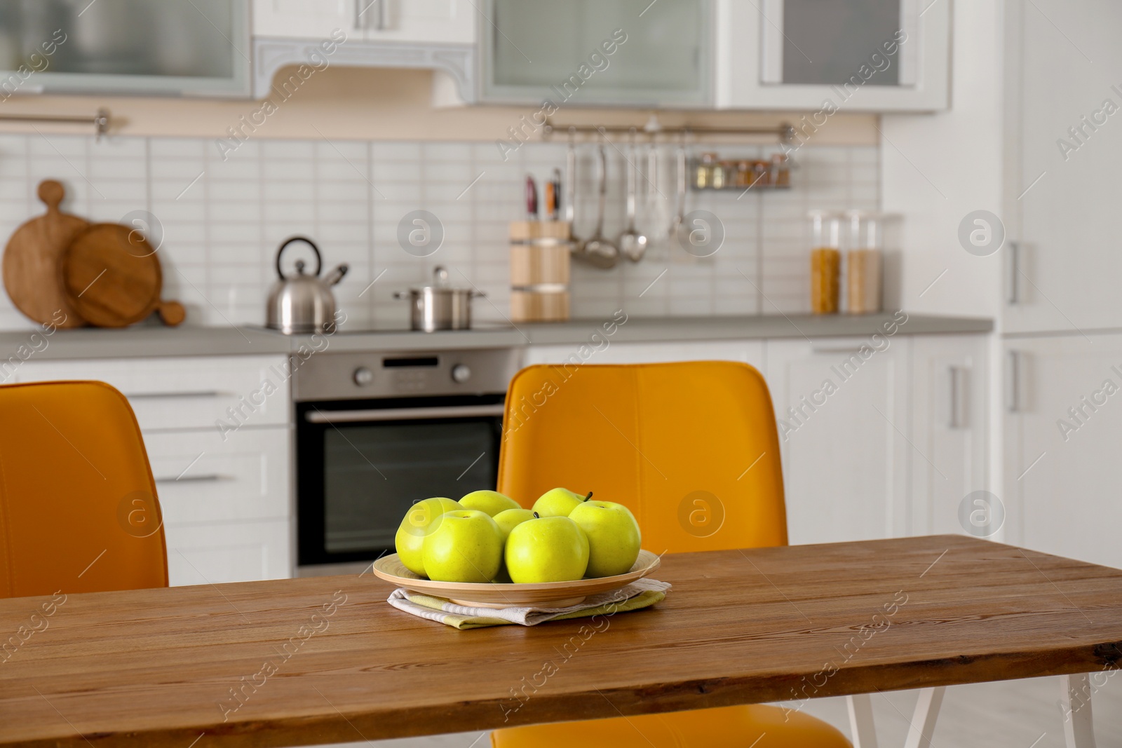 Photo of Table with ripe apples in stylish kitchen interior