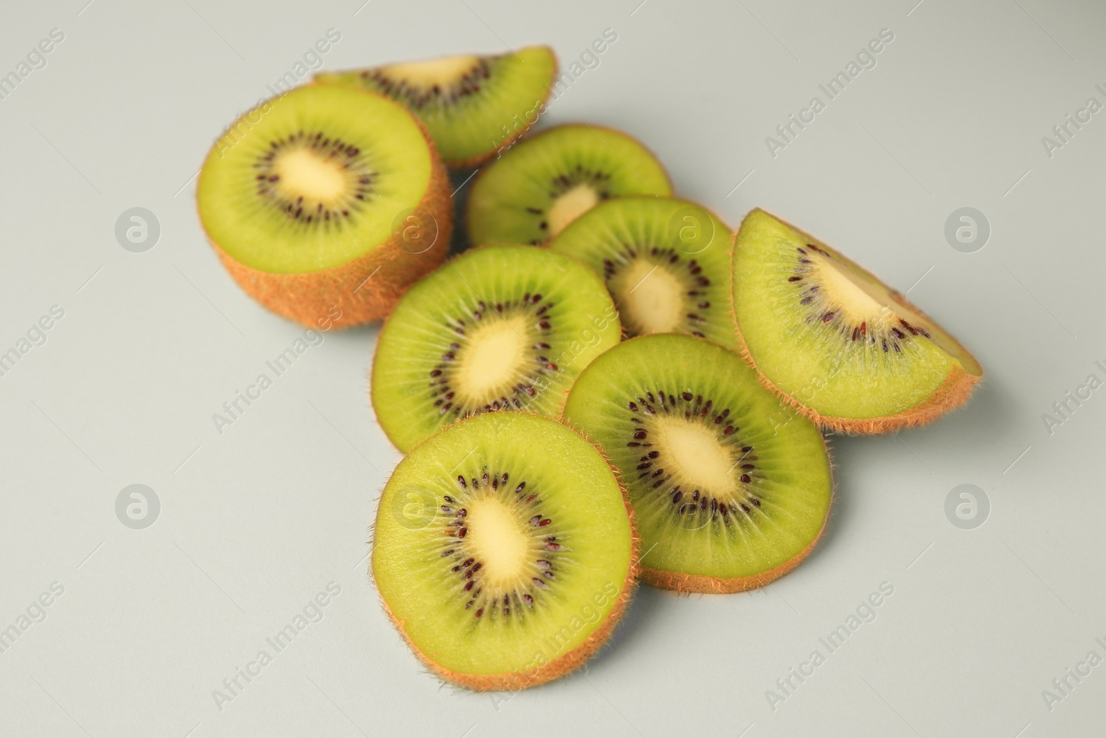 Photo of Cut fresh ripe kiwis on white background