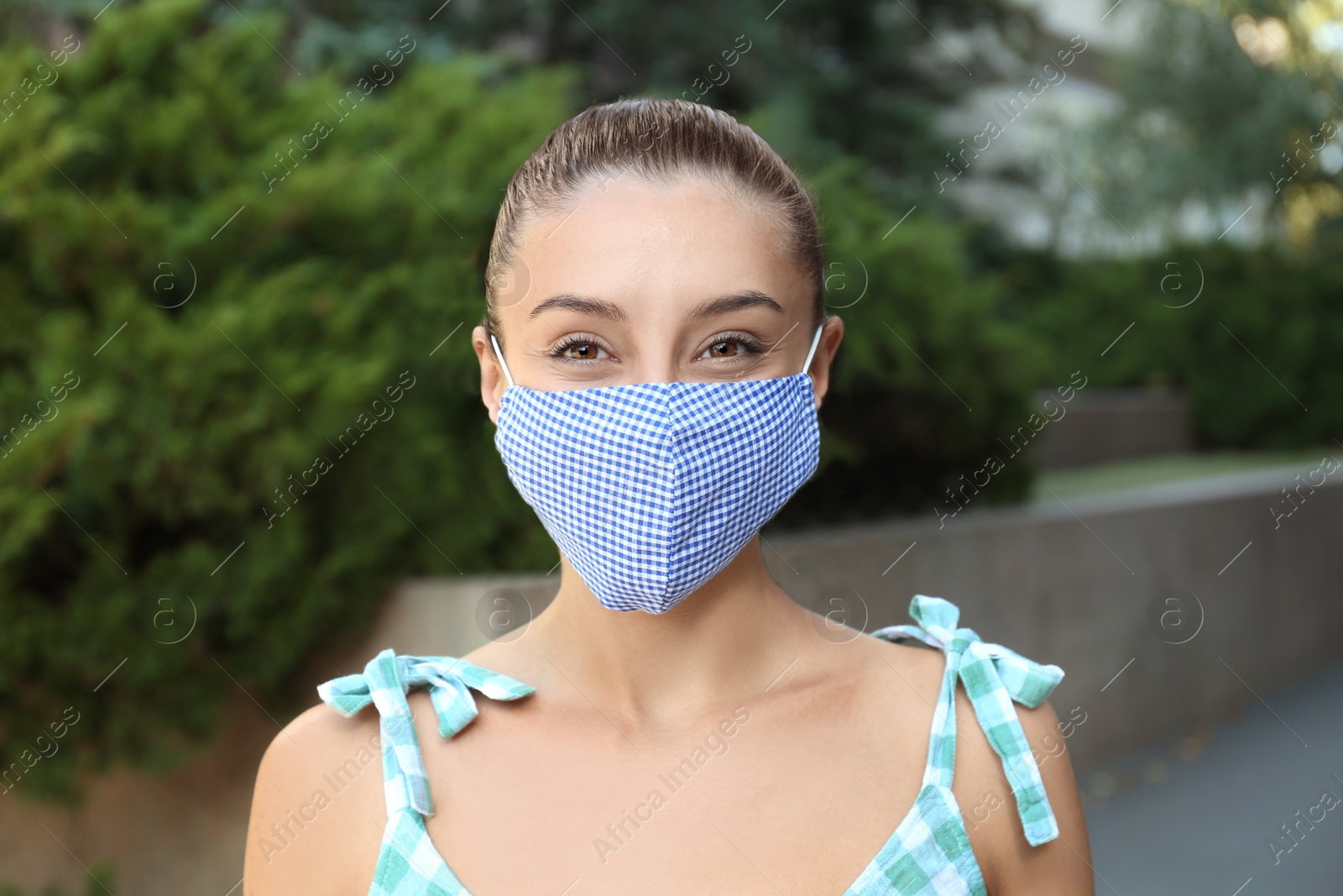 Photo of Woman wearing handmade cloth mask outdoors. Personal protective equipment during COVID-19 pandemic