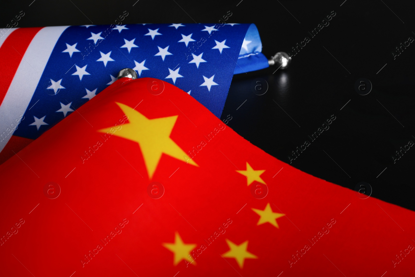 Photo of USA and China flags on black background, closeup