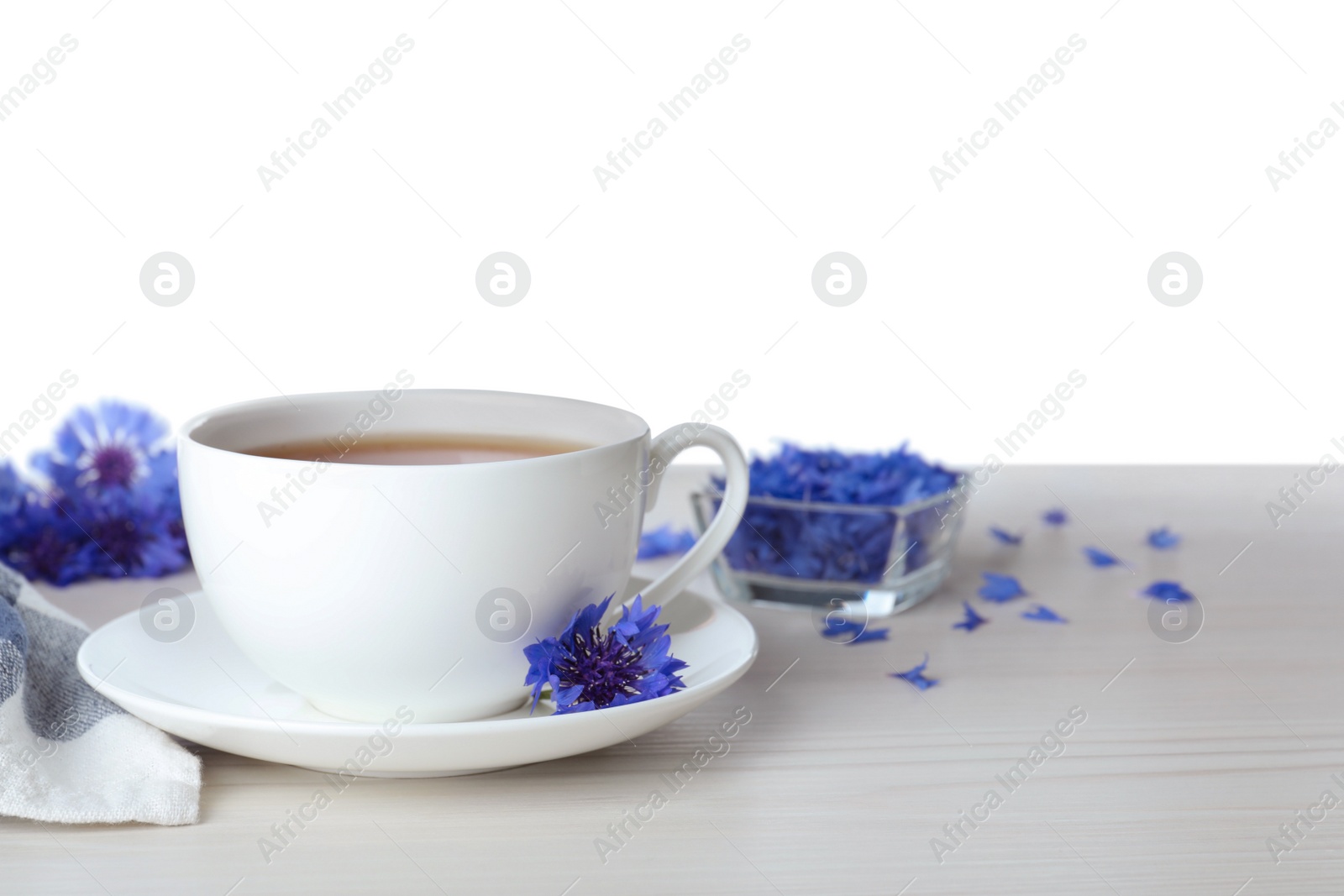 Photo of Cornflower tea and fresh flowers on white wooden table