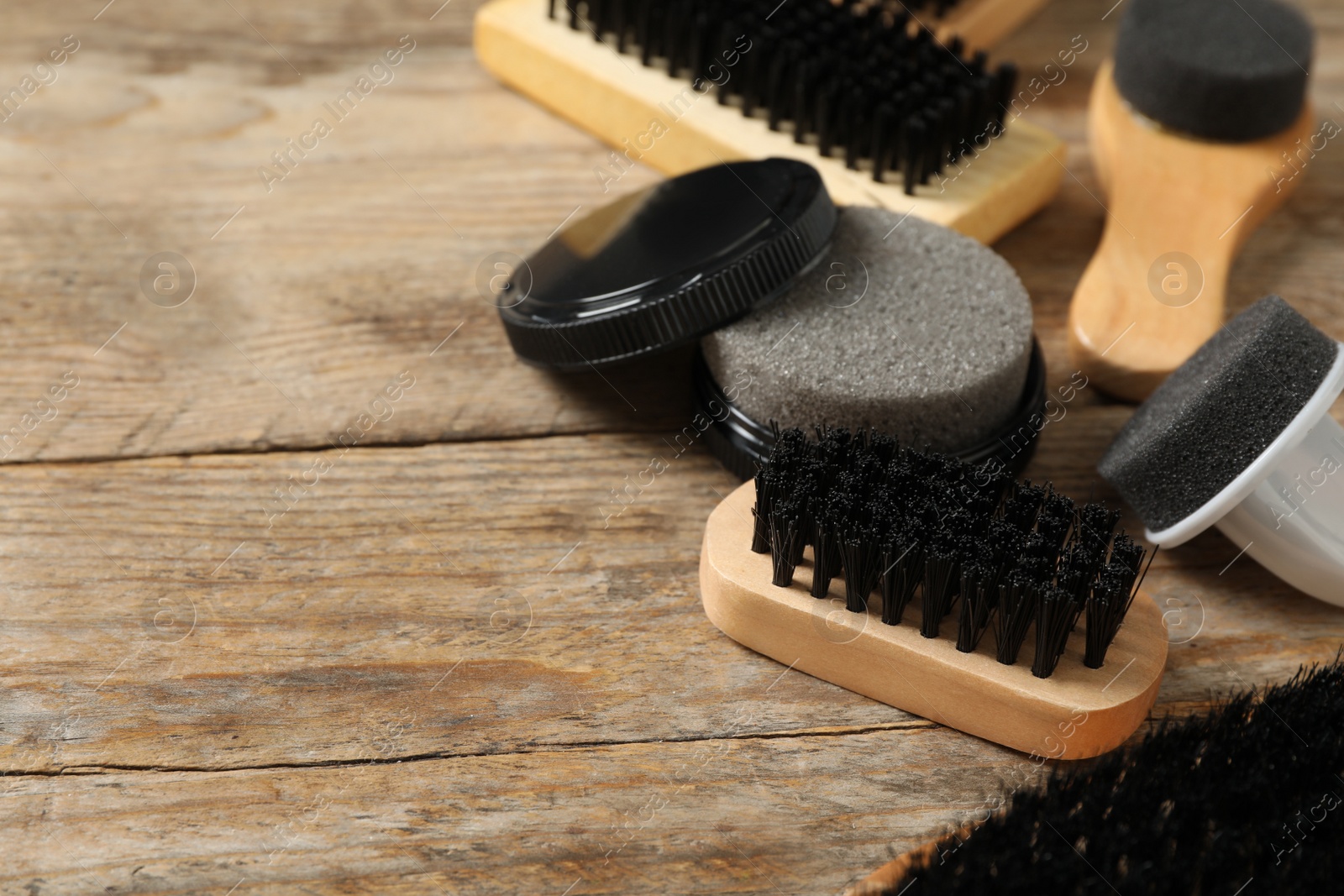 Photo of Composition with shoe care accessories on wooden background, closeup. Space for text