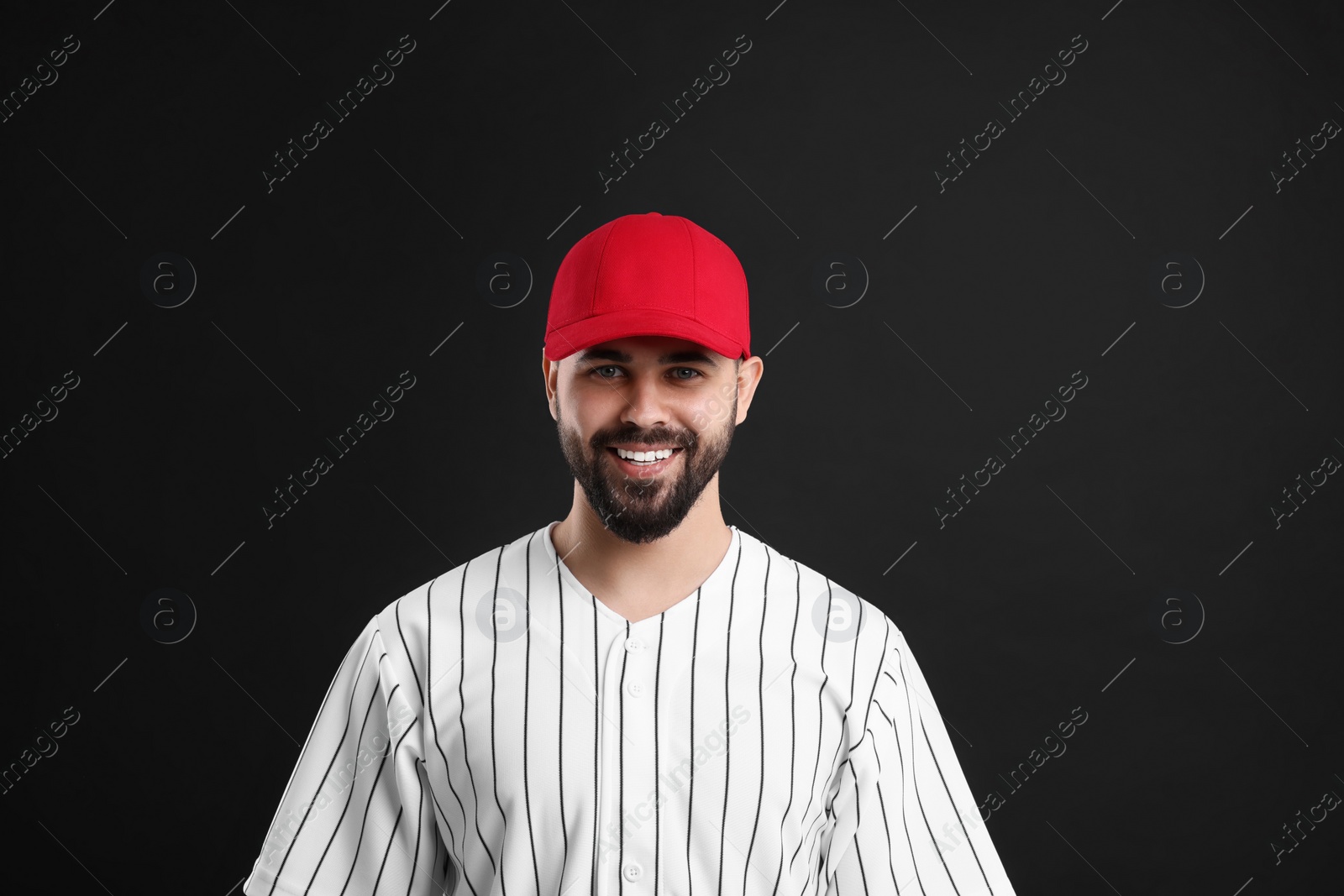 Photo of Man in stylish red baseball cap on black background