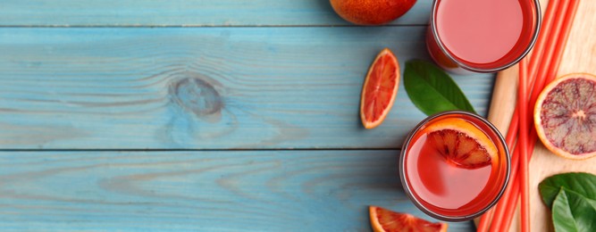 Tasty sicilian orange juice and fruits on light blue wooden table, flat lay with space for text. Banner design