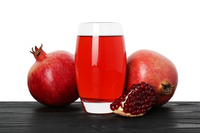 Photo of Refreshing pomegranate juice in glass and fruits on black wooden table against white background
