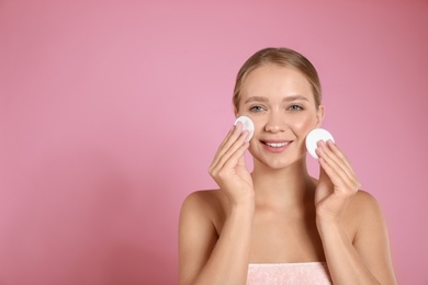 Photo of Beautiful young woman with cotton pads on pink background. Space for text