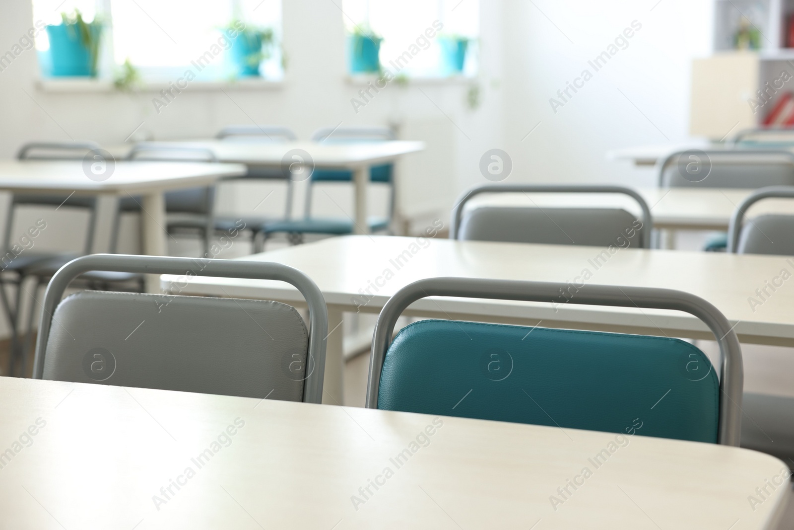 Photo of Empty school classroom with desks and chairs