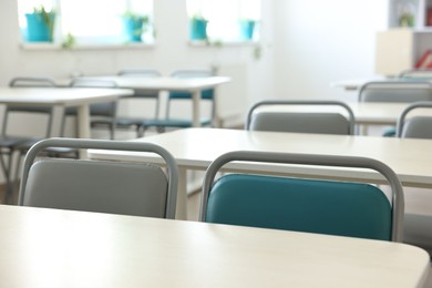 Photo of Empty school classroom with desks and chairs