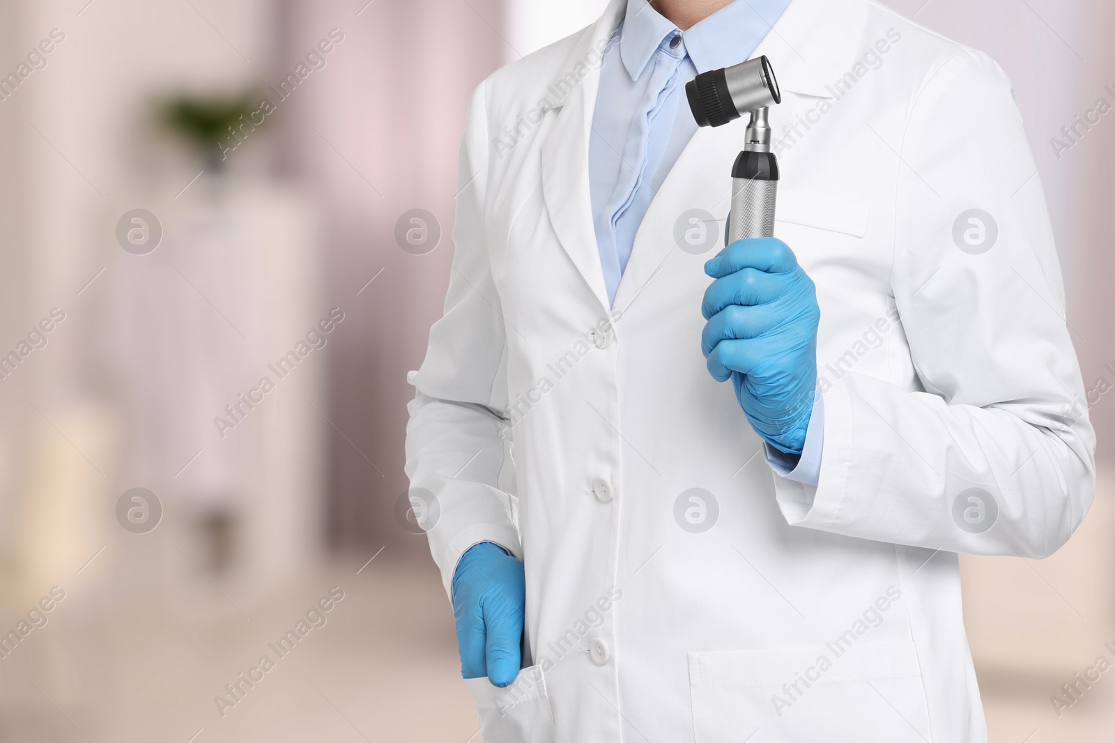 Image of Professional dermatologist with dermatoscope on blurred background, closeup