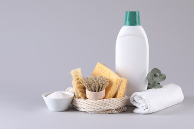 Bottles of cleaning product, sponges, brushes, rag and baking soda on light background. Space for text