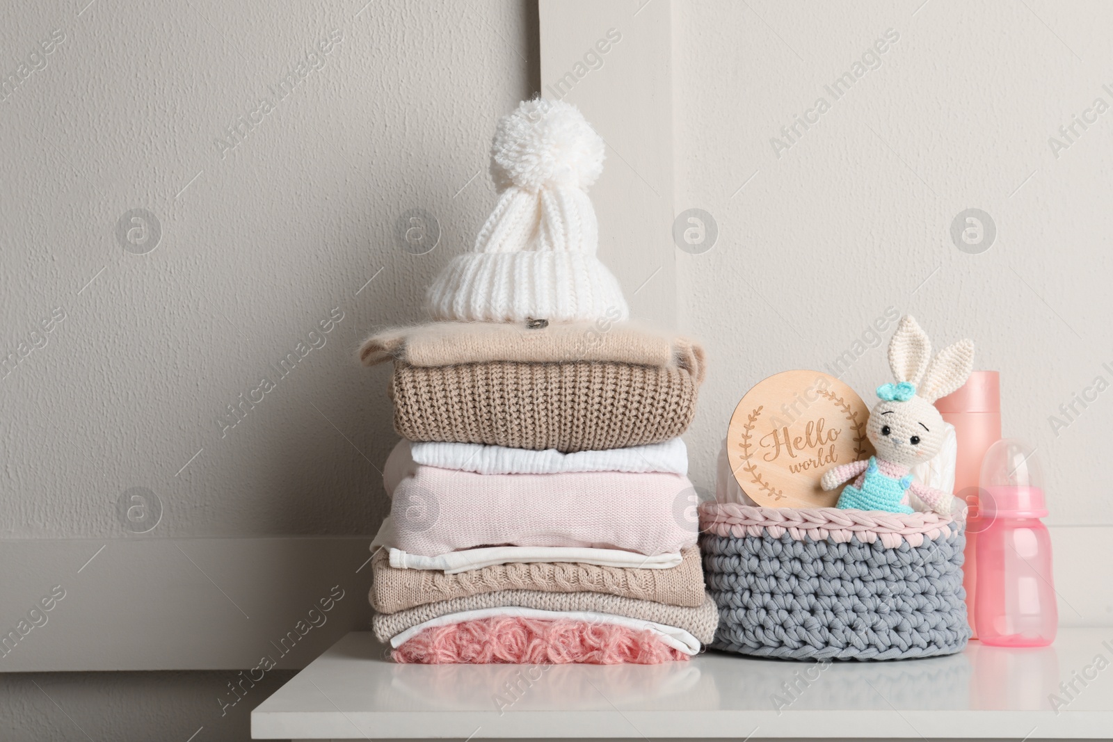 Photo of Baby clothes, toy and accessories on white table