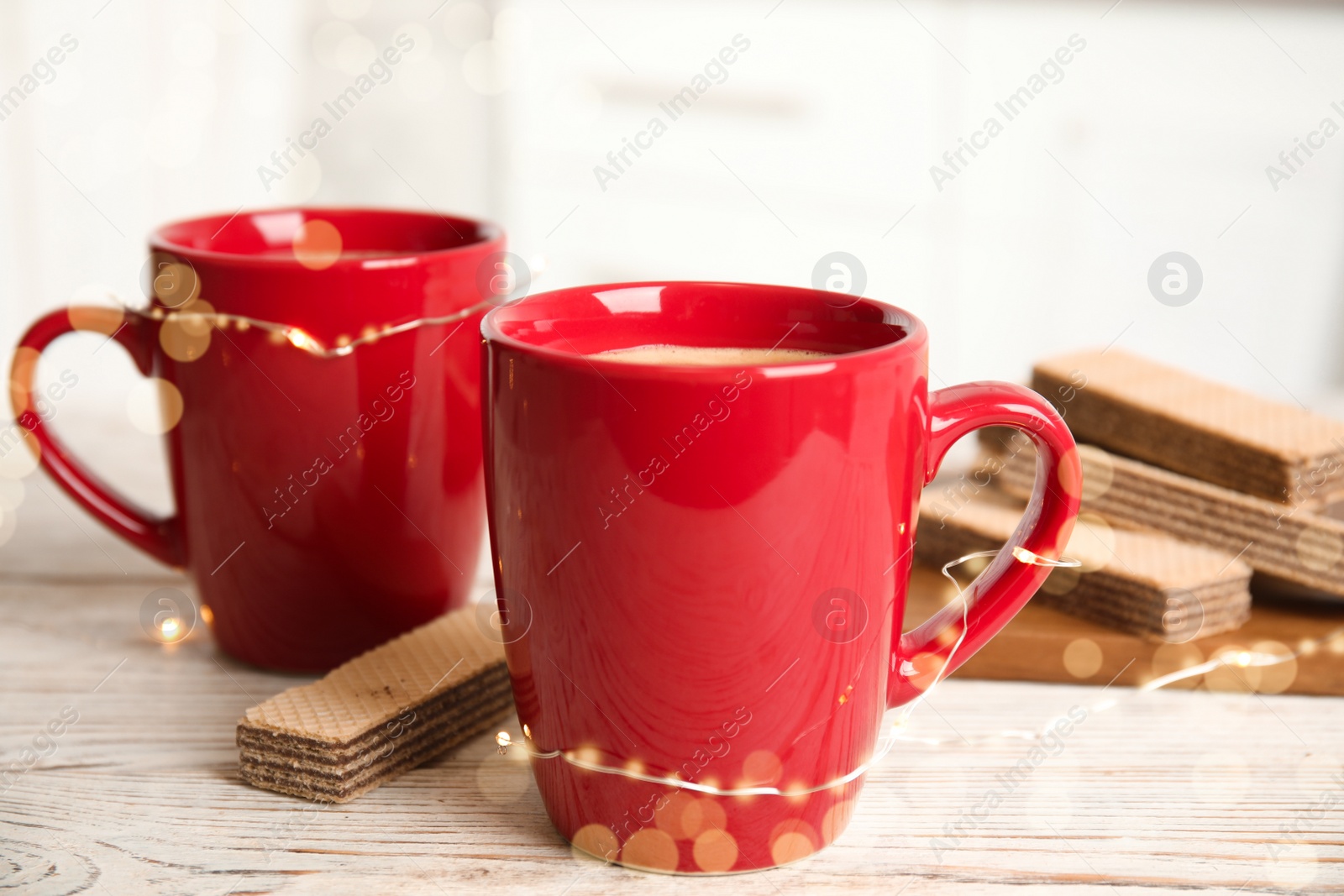 Photo of Breakfast with delicious wafer and cups of coffee on white wooden table