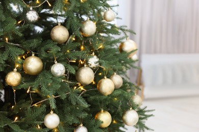 Photo of Beautiful Christmas tree with festive lights and colorful balls indoors
