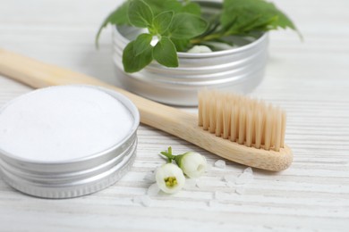 Toothbrush, dental products and herbs on white wooden table, closeup