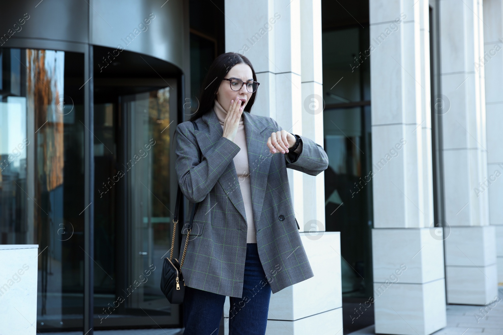 Photo of Emotional woman checking time on watch outdoors. Being late concept