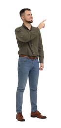 Man in shirt and jeans pointing at something on white background