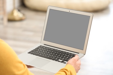 Young man using video chat on laptop at home, closeup. Space for design