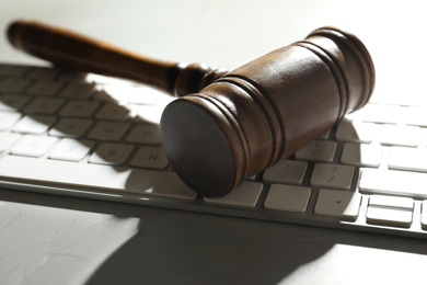 Photo of Gavel and computer keyboard on grey table. Cyber crime