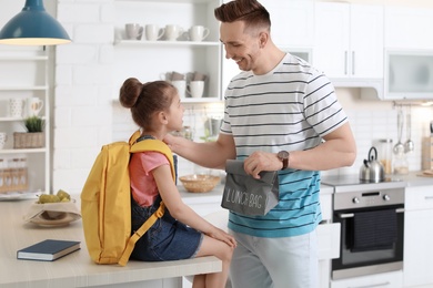 Young man helping his little child get ready for school at home